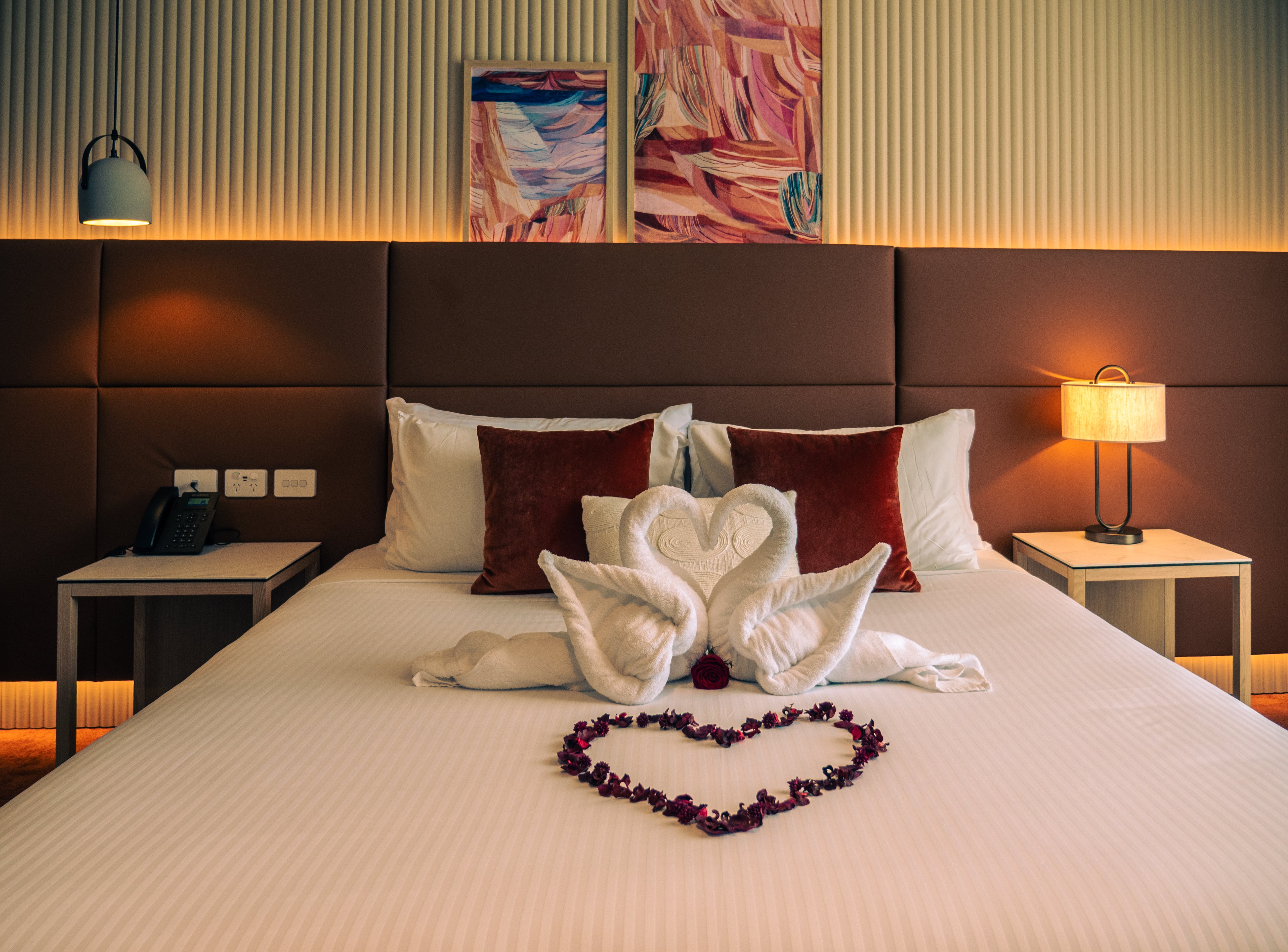 A calm and relaxing hotel room with decorative swan-towels and a love-heart on the bed, perfect for a Valentine's Day stay at Encore by Mingara.